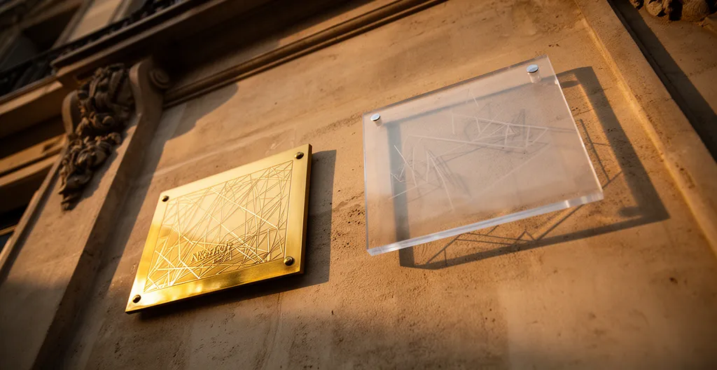 Comparaison de plaques professionnelles en laiton doré et plexiglas transparent sur une façade de cabinet médical