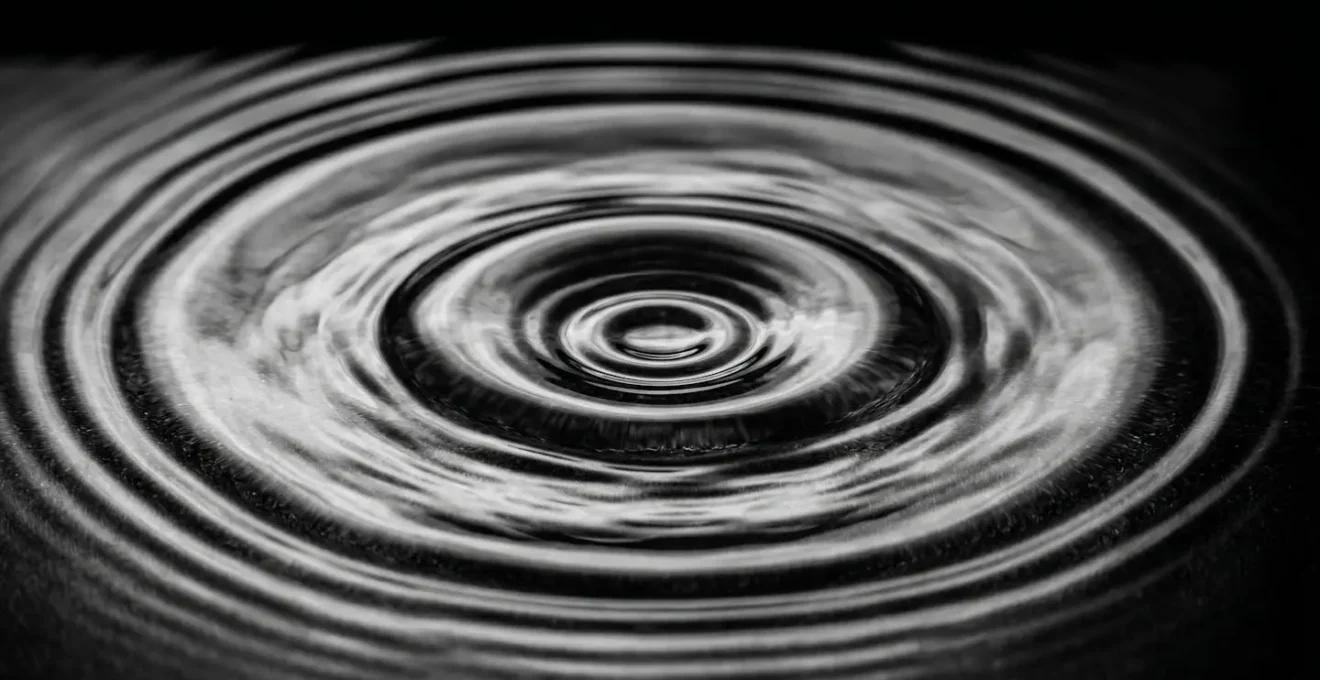 Gros plan macro sur des ondulations d'eau créant des cercles concentriques lumineux